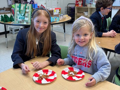 Older and Younger SLES students sharing snacks at a table