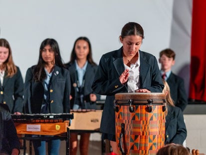 SLES students playing drums in performance