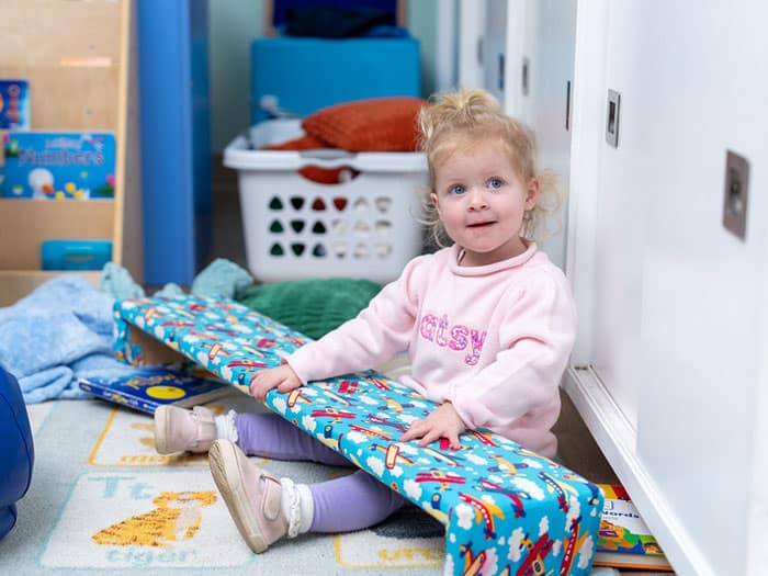 Toddler sitting on the floor and smiling