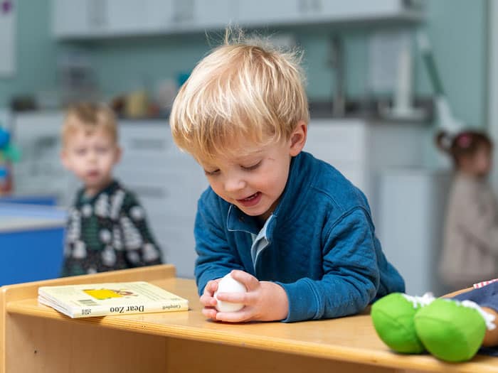 Toddler boy sitting at the desk and smiling