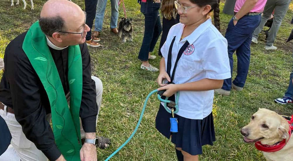 Priest and student at blessing of the pets at St. Luke's Episcopal School