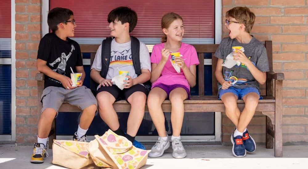 Episcopal school students sitting on a becnh